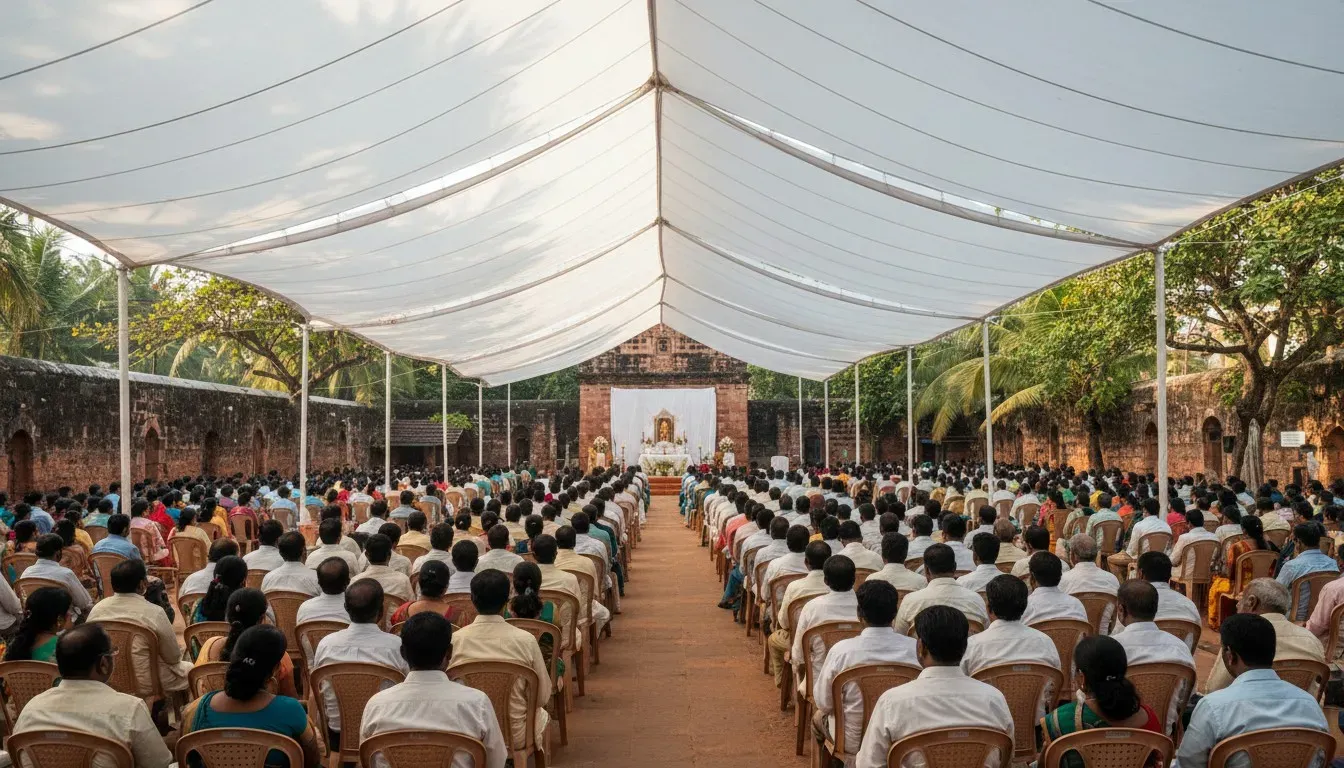 Large outdoor congregation of devotees gathered under a white canopy on church grounds in Old Goa.